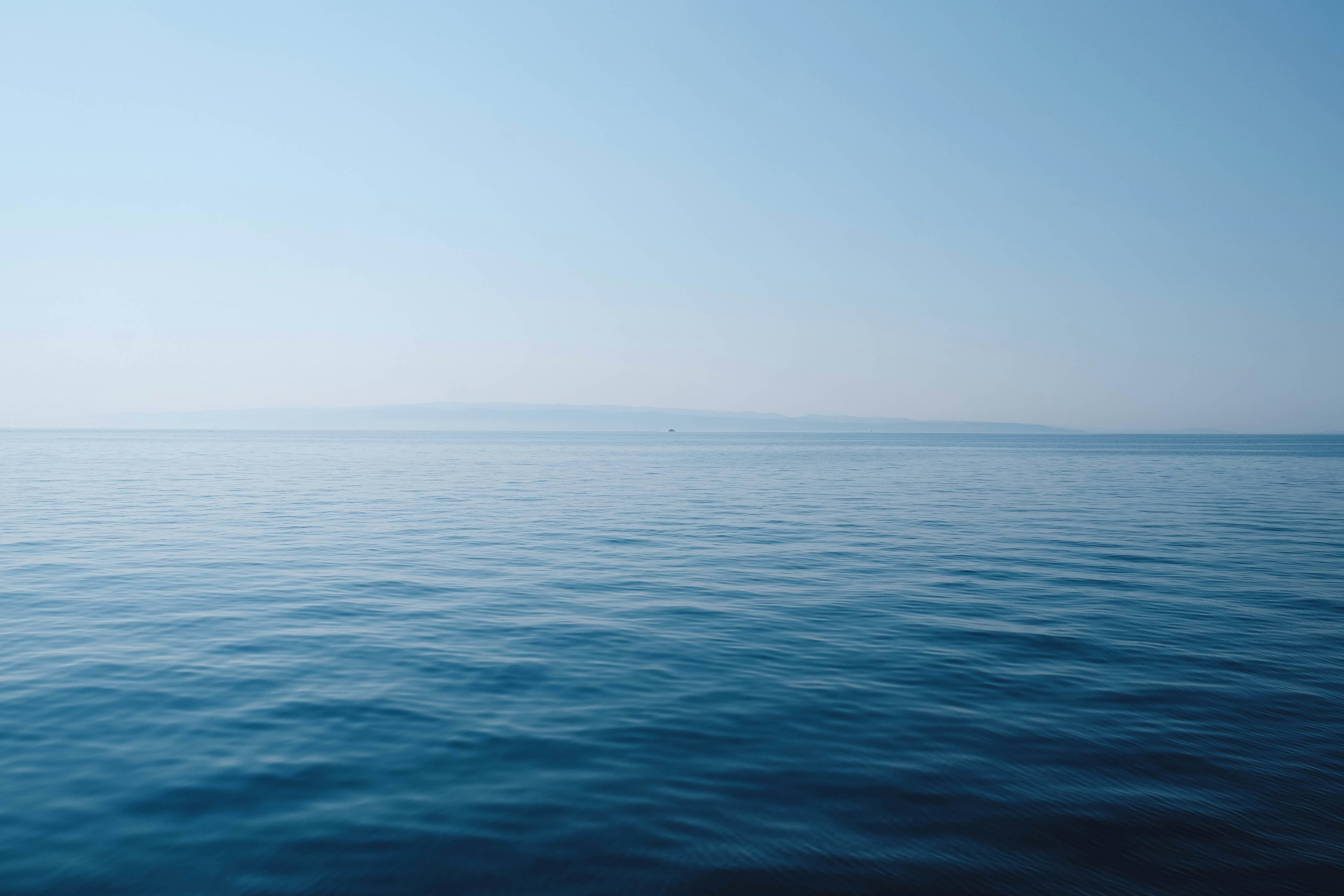 Calm blue water beneath a bright open sky